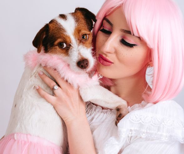 Dog and owner Halloween costumes featuring a woman in a pink wig with her dog dressed in a fluffy pink tutu.